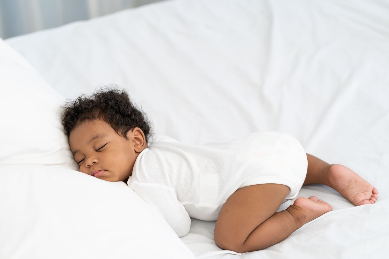 Afro-Amerikan bebek beyaz şilte üzerinde uyuyor.