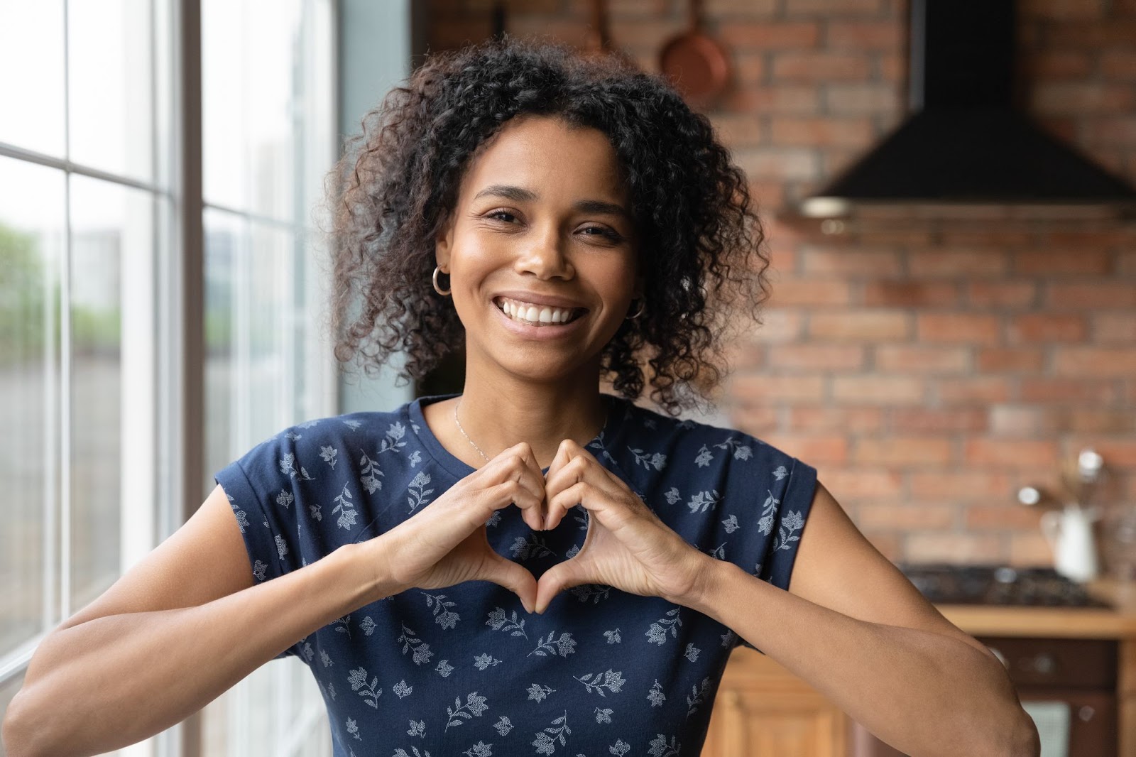 Elleriyle bir kalp gösteren genç afro amerikalı kadın ILY konsepti
